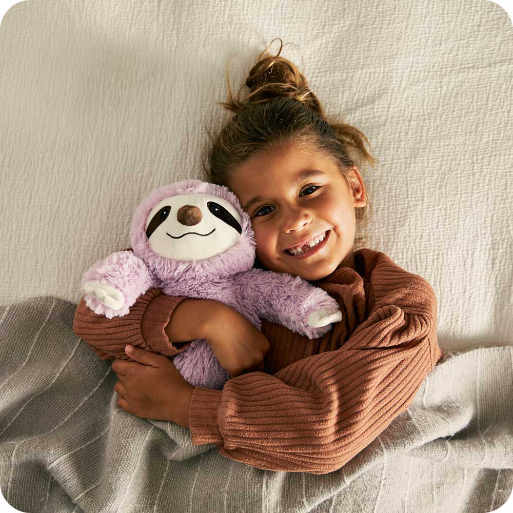 Child laying down with Cute Weighted Lavender Scented Purple Sloth Stuffed Animal Heating Pad Warmies