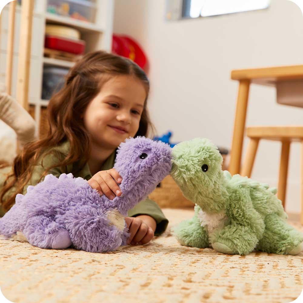 Child playing with Soft Warm Weighted Green Long Neck Dinosaur Plush Warmies