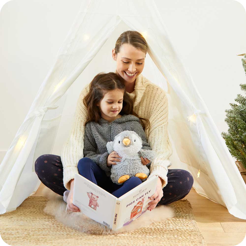Mother and daughter reading a book with Soft Warm Weighted Gray Penguin Plush Warmies
