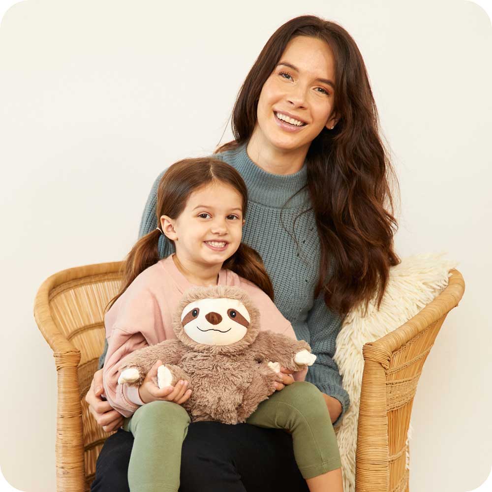 Mother and daughter sitting down holding Plush Lavender Scented Sloth Warmies