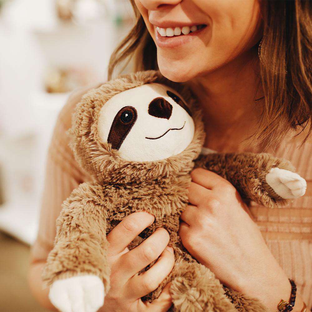 Woman cuddling Soft Warm Weighted Sloth Plush Warmies