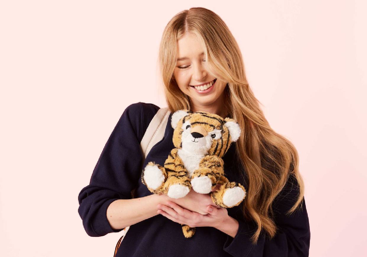 Young adult holding a weighted stuffed animal for stress-relief.