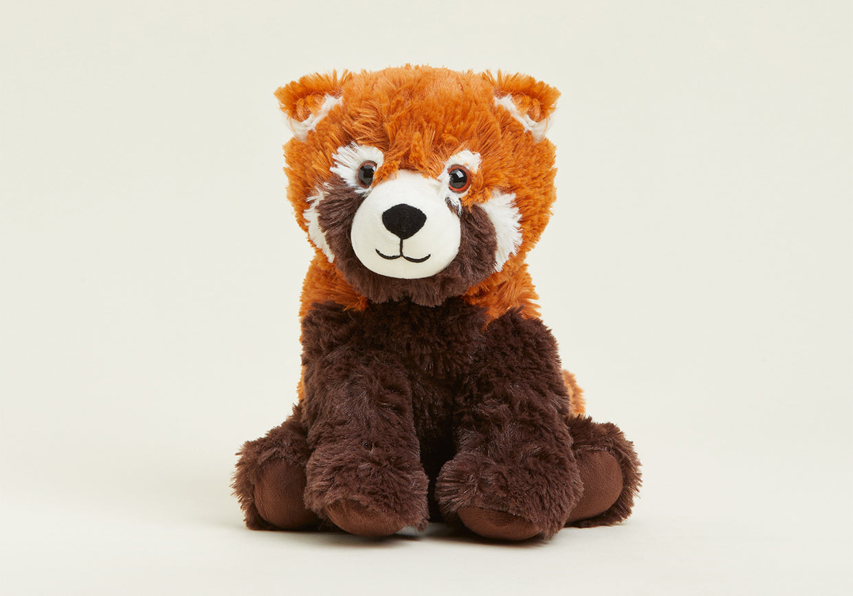 Cute red panda stuffed animal sitting on a shelf.
