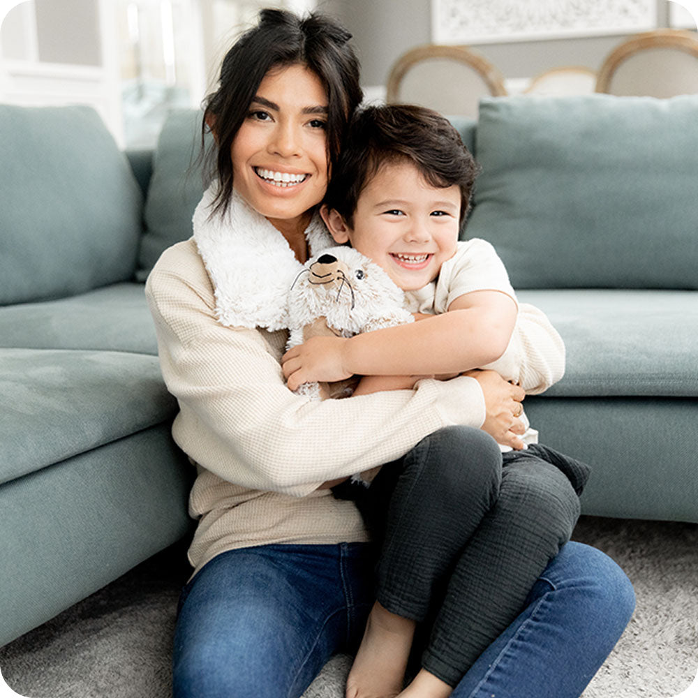 A woman and child with a Seal Warmies and heatable neck wrap Warmies.