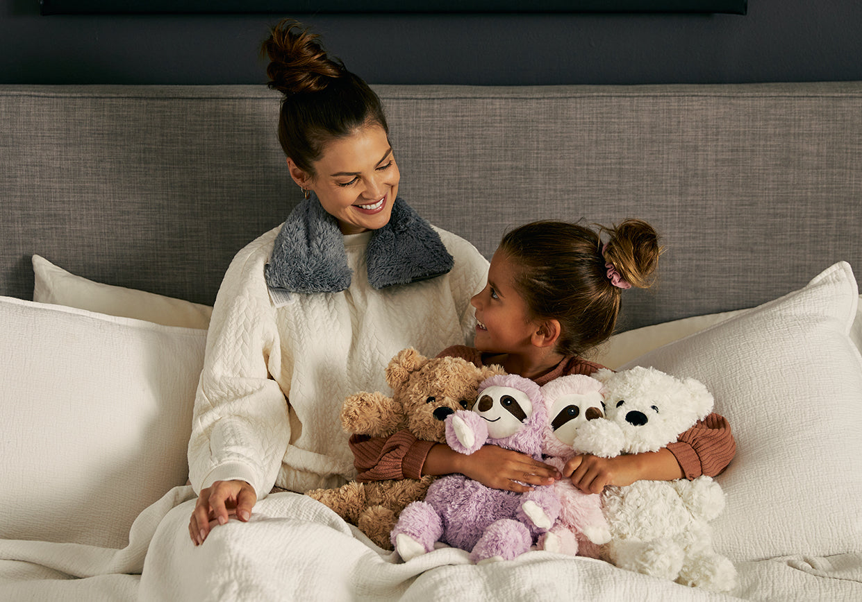 Woman with child relaxing before bed with Warmies.