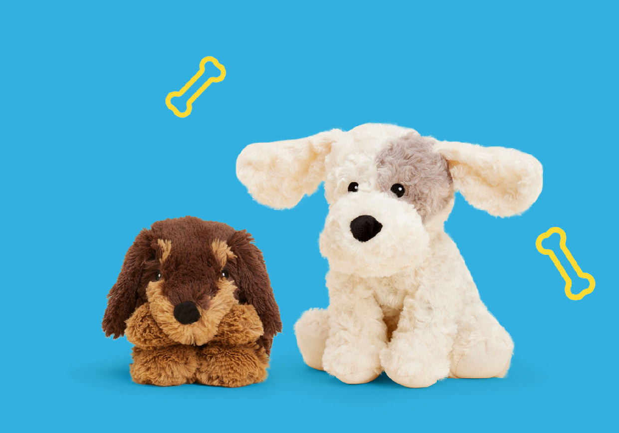 A Dachshund stuffed animal Warmies and a Patch Curly Dog Warmies on a blue background with a drawing of a dog bone.