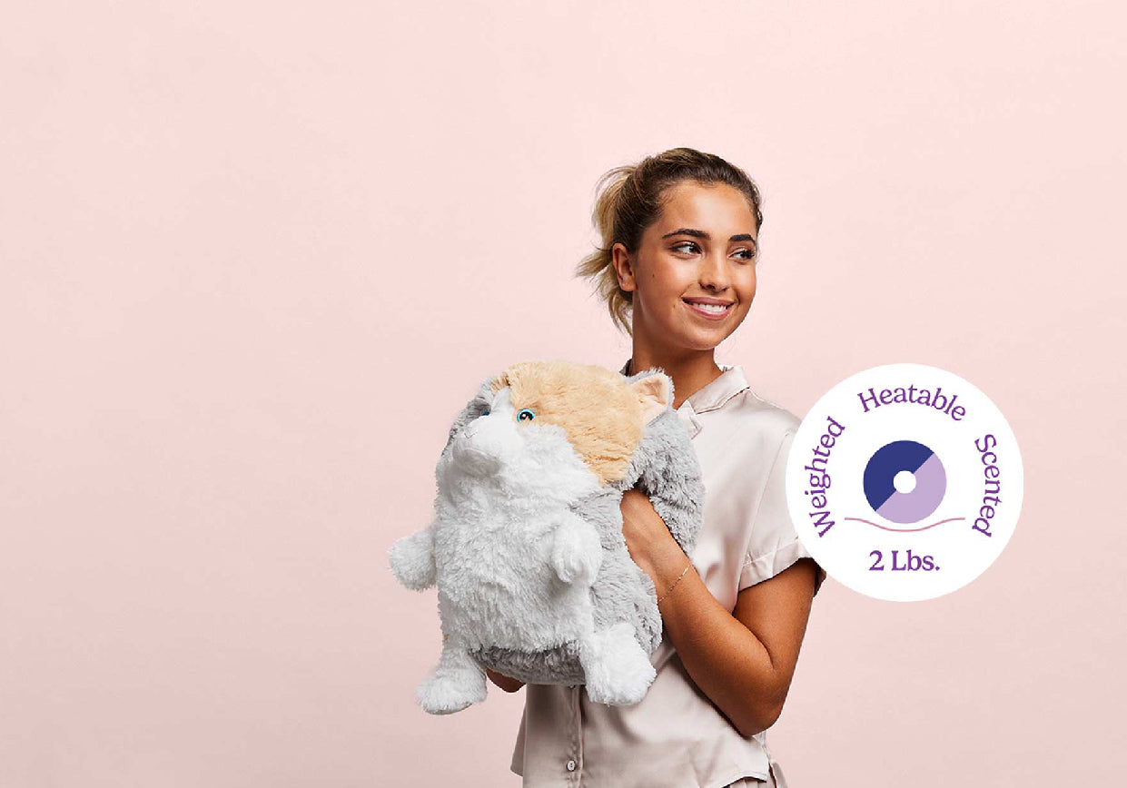 A young woman with a Supersized Cat Warmies and Heatable, Weighted, Scented (2lbs logo)