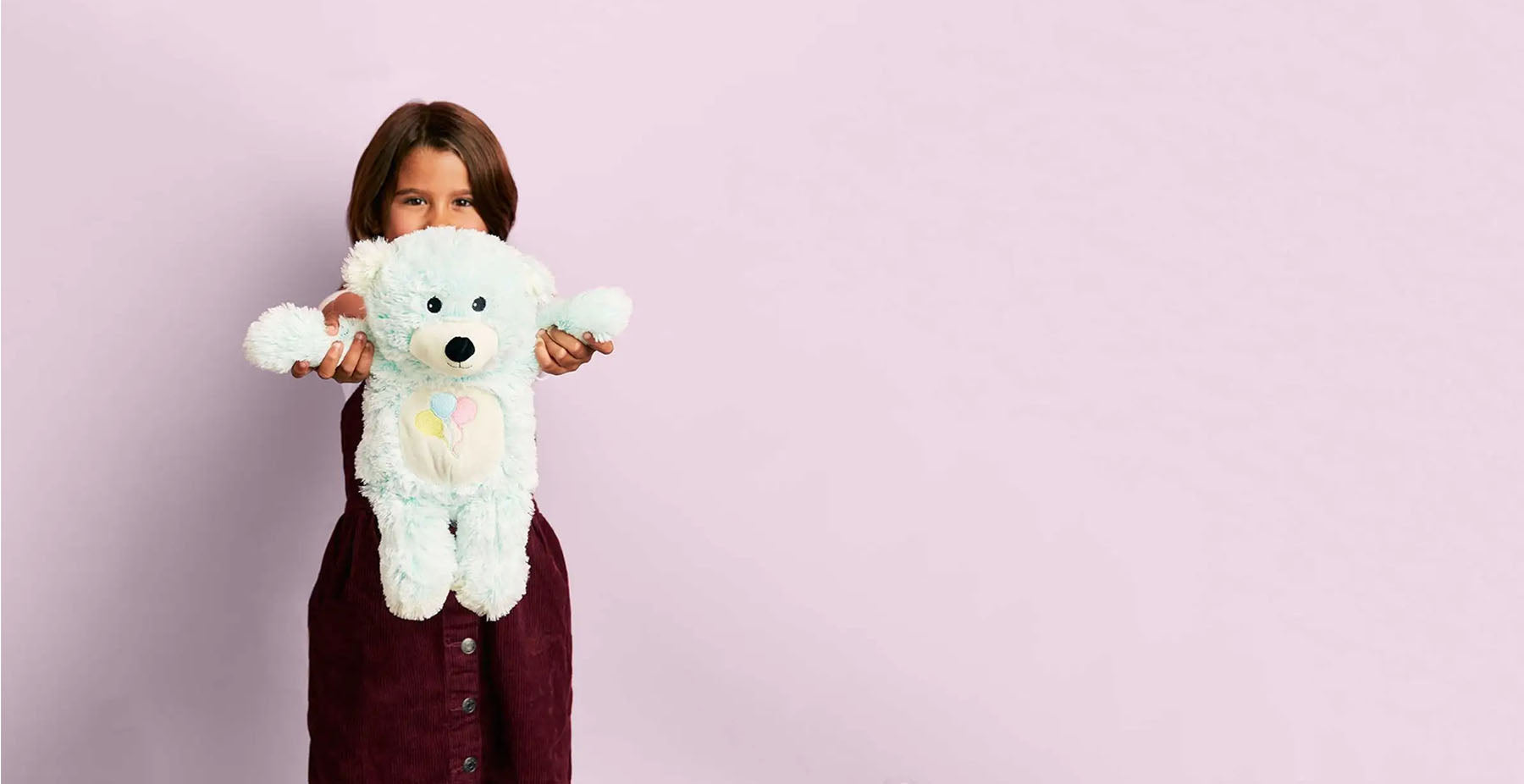 girl holding celebration teddy bear stuffed animal warmies