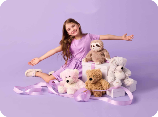 Child with various Warmies stuffed animals and gift and present boxes. 
