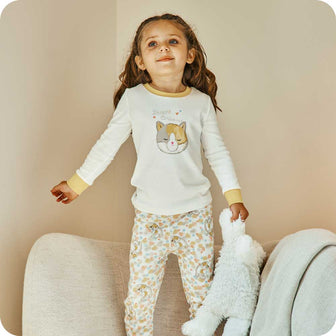Toddler holding Soft Plush Warmies while wearing Calico Cat Pajamas - Warmies 