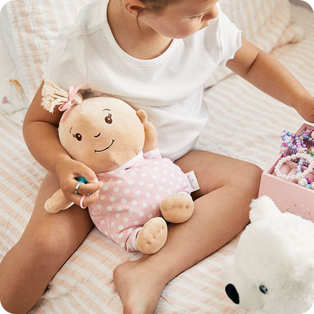 girl holding warmies baby girl stuffed animal