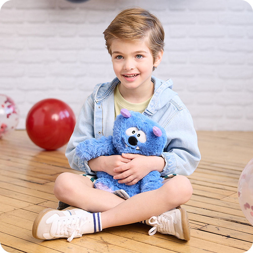 boy holding blue monster stuffed animal