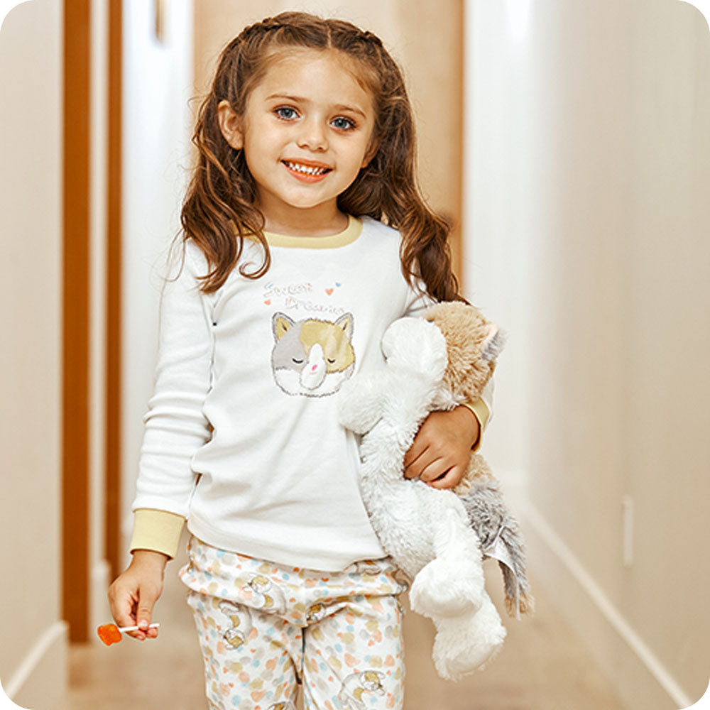 girl holding calico cat warmies in cat pjs