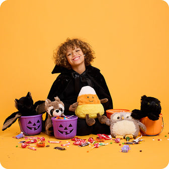boy with halloween candy corn stuffed animals