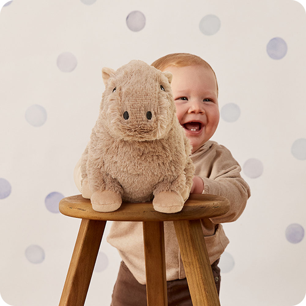 baby laughing with capybara stuffed animal warmies