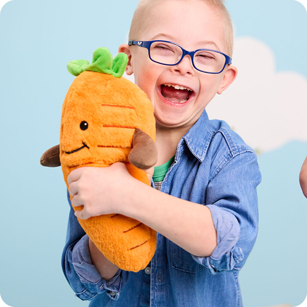 boy holding carrot stuffed animal warmies
