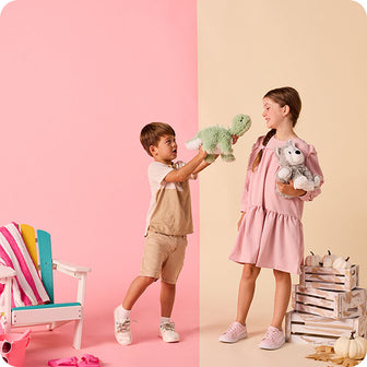 boy holding green long neck dino stuffed animal