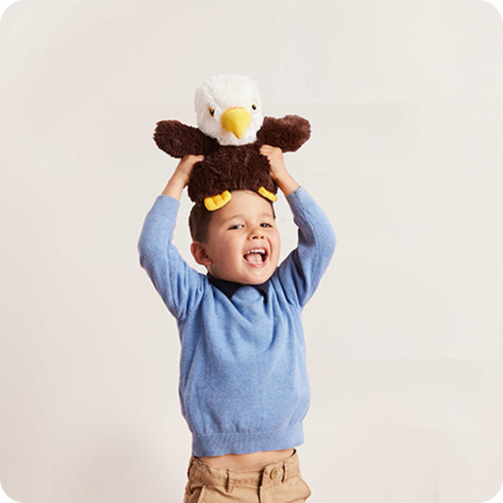 boy holding an eagle stuffed animal on his head