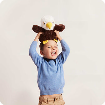 boy holding an eagle stuffed animal on his head