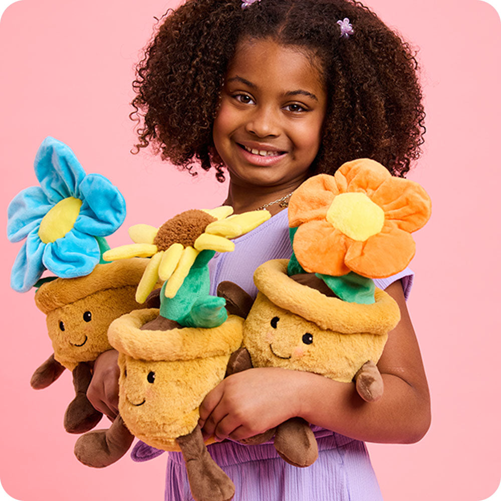 girl holding three flower pot stuffed animal warmies