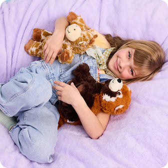 girl holding giraffe and red panda stuffed animals