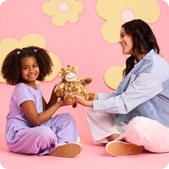 mother and daughter holding giraffe stuffed animal