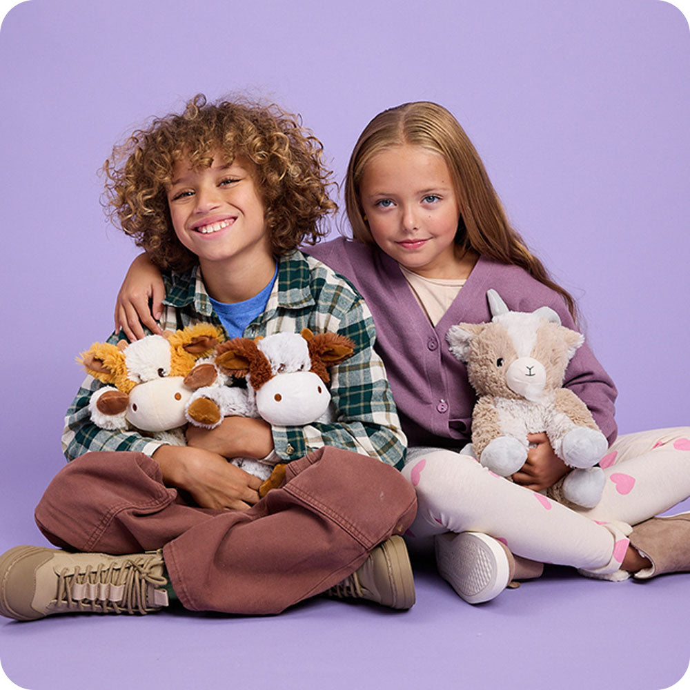 boy and girl hugging stuffed animals warmies