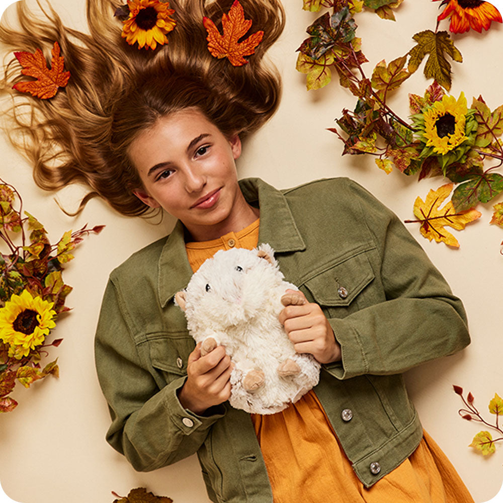 autumn decorations around teen holding hamster stuffed animal
