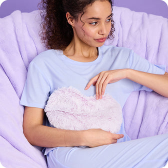 girl holding lavender heart warmies