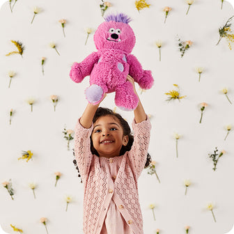 girl holding pink monster stuffed animal