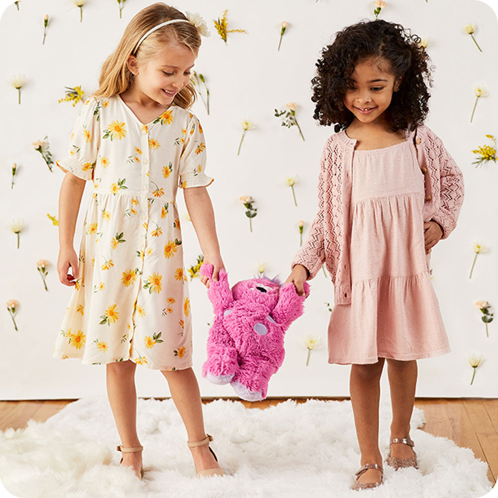 two girls holding cute pink monster stuffed animal