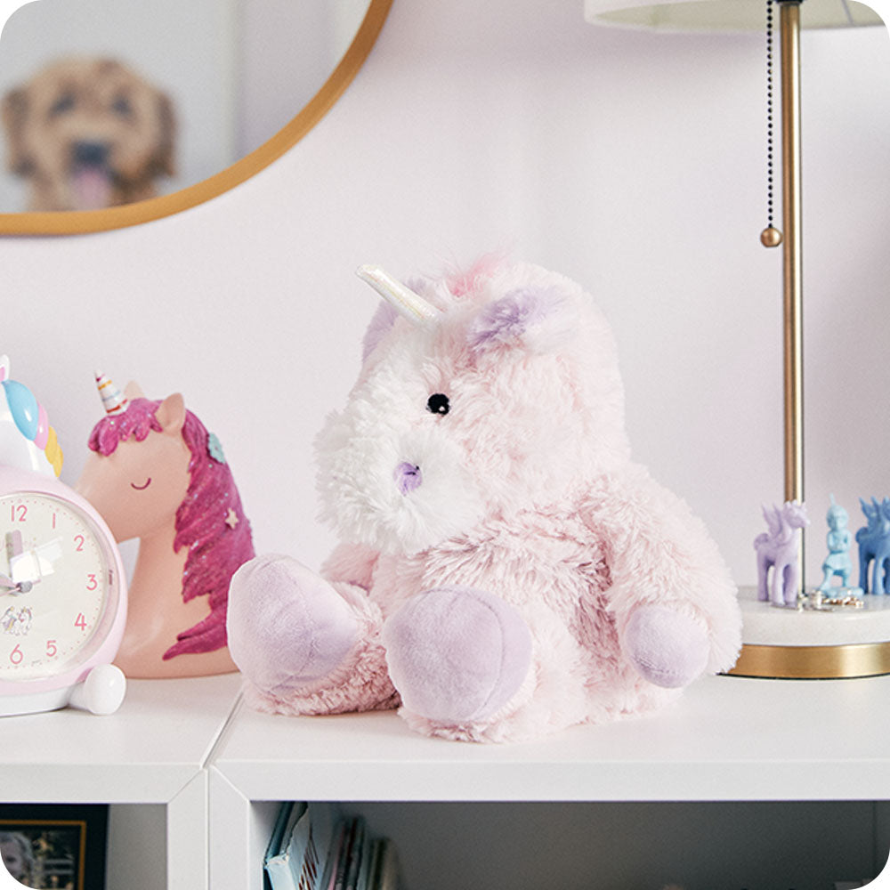 pink unicorn stuffed animal on girls bookshelf