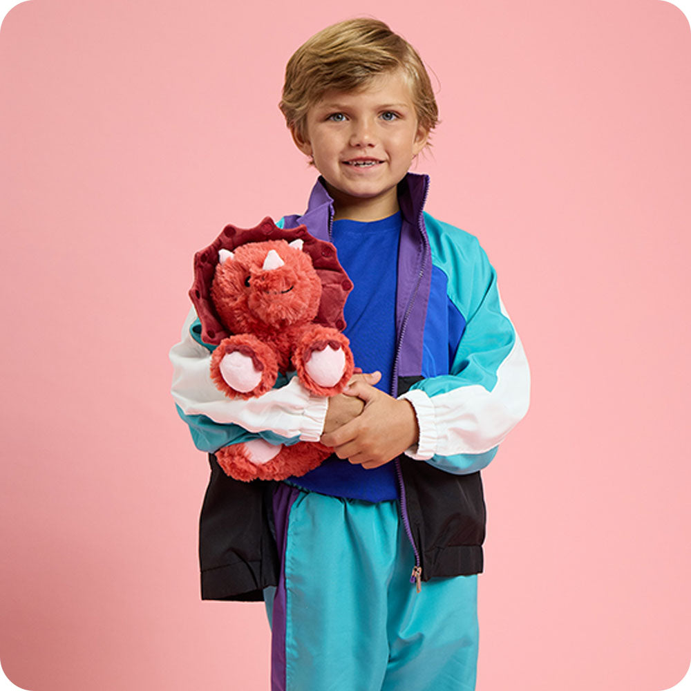 boy holding red triceratops stuffed animals