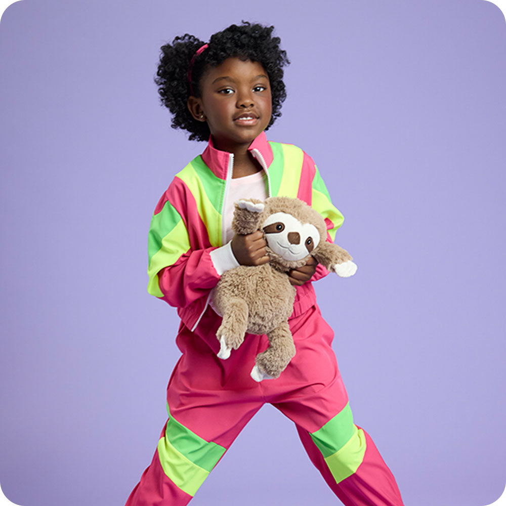 girl holding sloth stuffed animal with purple background