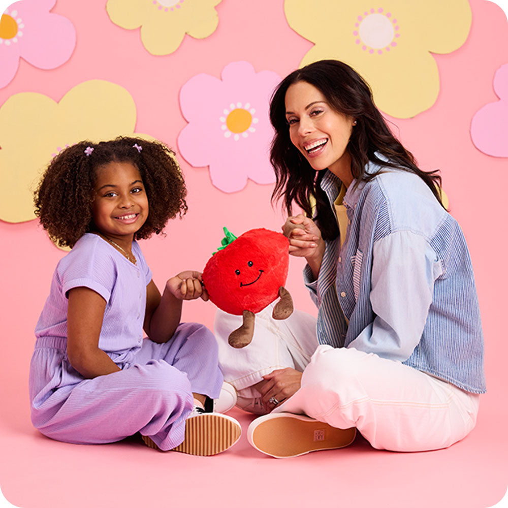 mom and daughter holding tomato stuffed animal