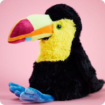warmies toucan stuffed animal on pink background