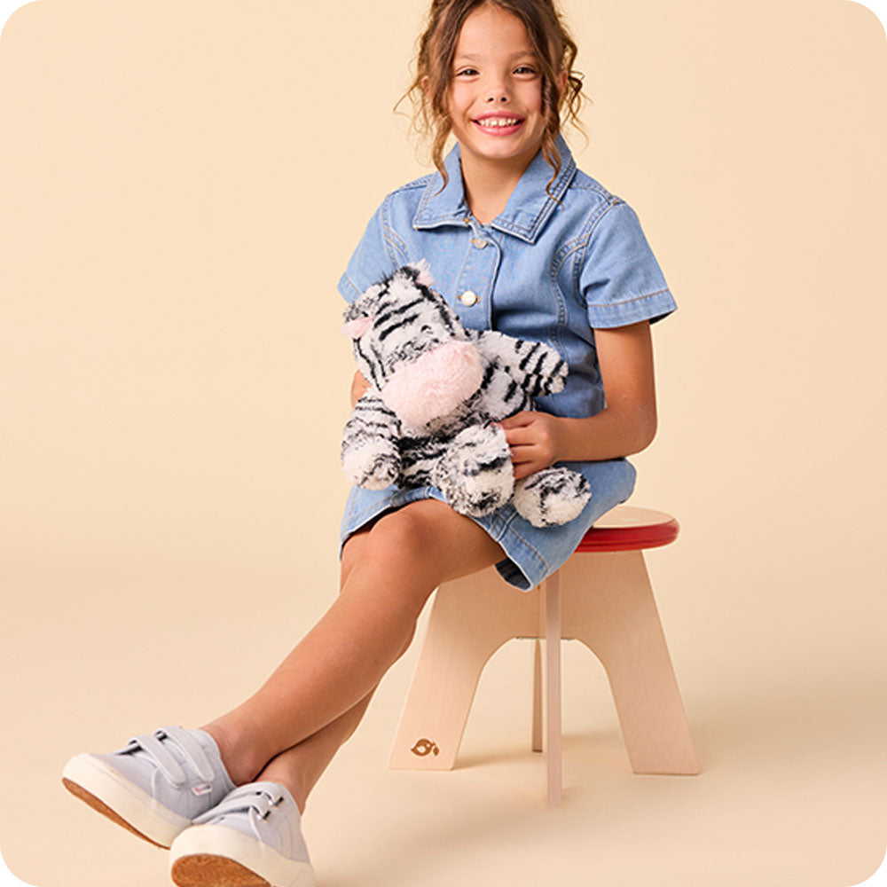 girl hugging zebra stuffed animal warmies