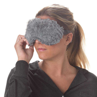 Woman wearing Gray Warmies Eye Mask: Microwavable tranquility for soothing comfort.